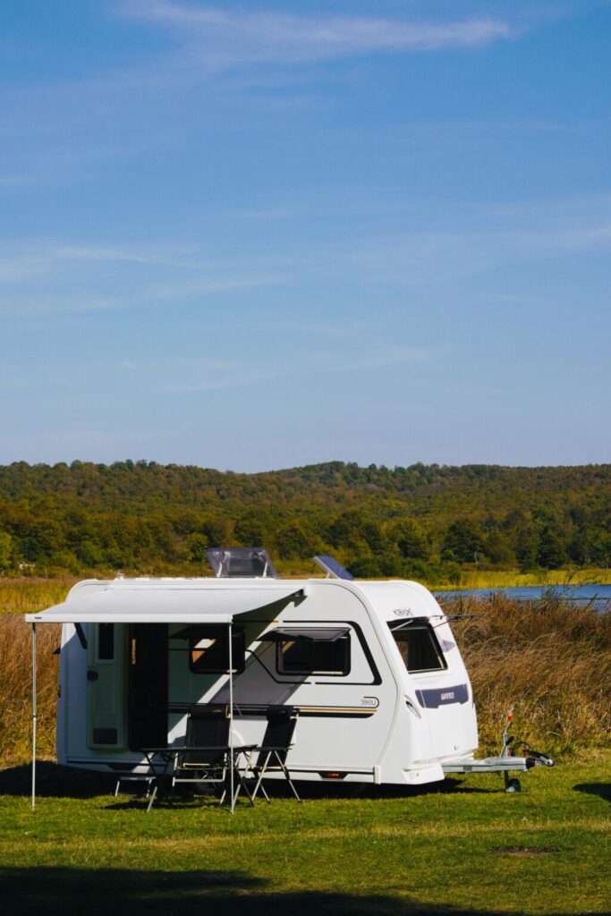 Witte caravan met uitgeschoven luifel op een camping