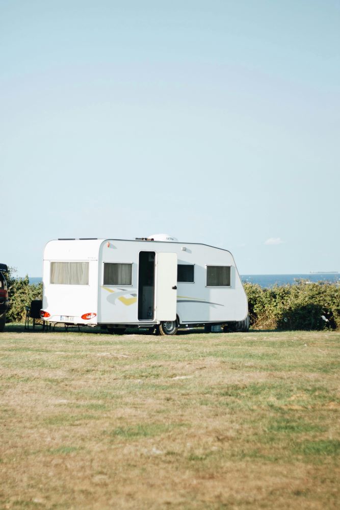 Witte caravan op een open grasveld